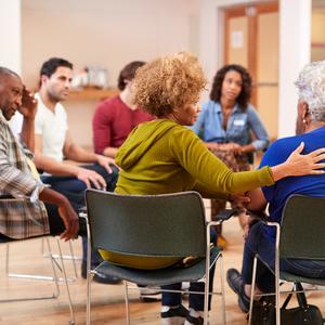 Woman in group of people being supportive of older adult